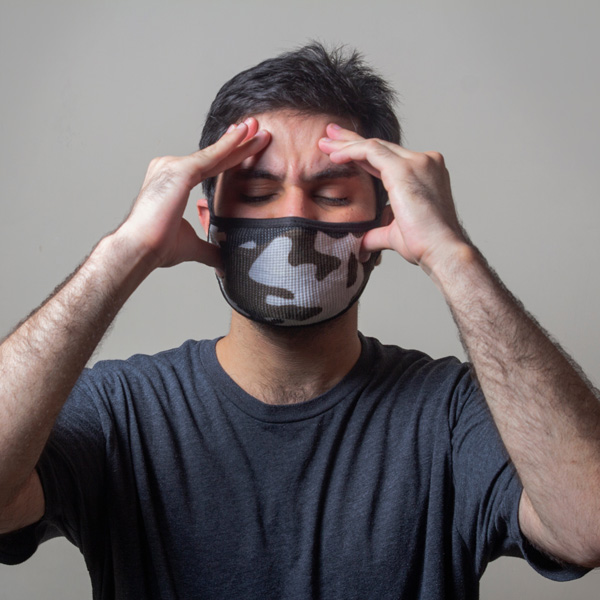 young man with his fingertips on his forehead and cheeks in pain